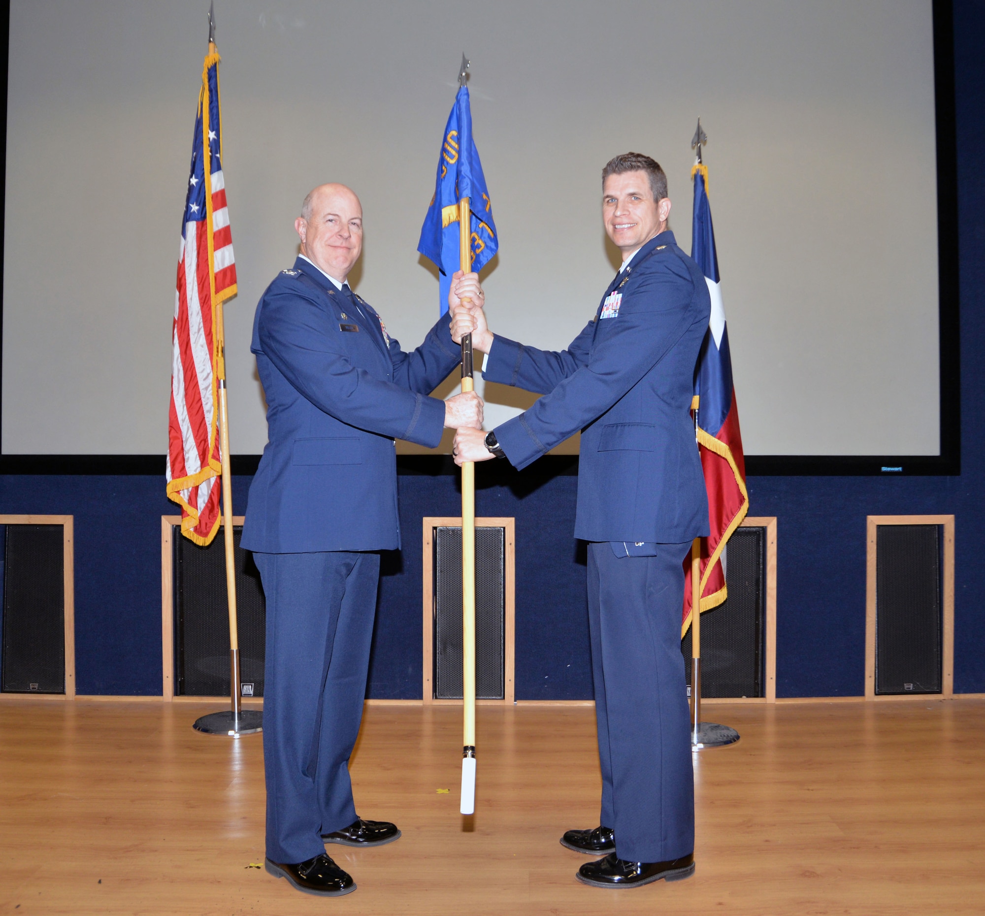 Col. James “J.C.” Miller, 433rd Operations Group commander, hands the 733rd Training Squadron’s guidon to Lt. Col. Seth W. Asay signifying the transition of command Dec. 7, 2019 at Joint Base San Antonio-Lackland, Texas.