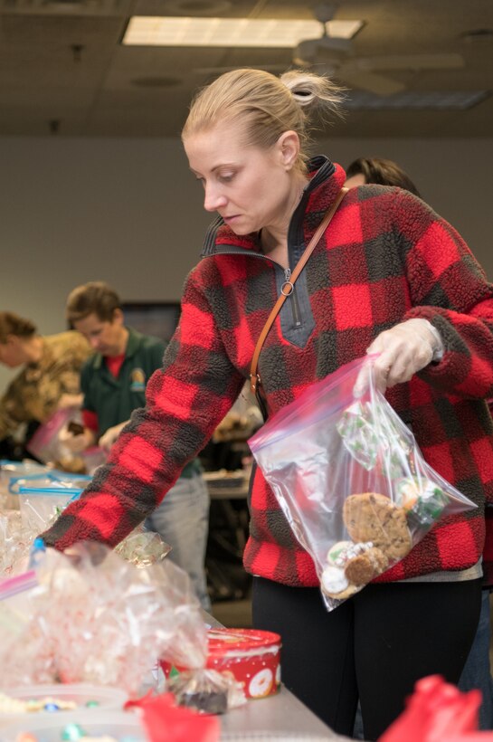 Christie Jones fill bags with cookies and baked goods during Operation Cookie Drop Dec. 9, 2019, at the 9th Airlift Squadron on Dover Air Force Base, Del. The cookies were baked and donated by members of the local community in hopes of sharing some holiday cheer to Airmen living in the dormitories. (U.S. Air Force photo by Mauricio Campino)