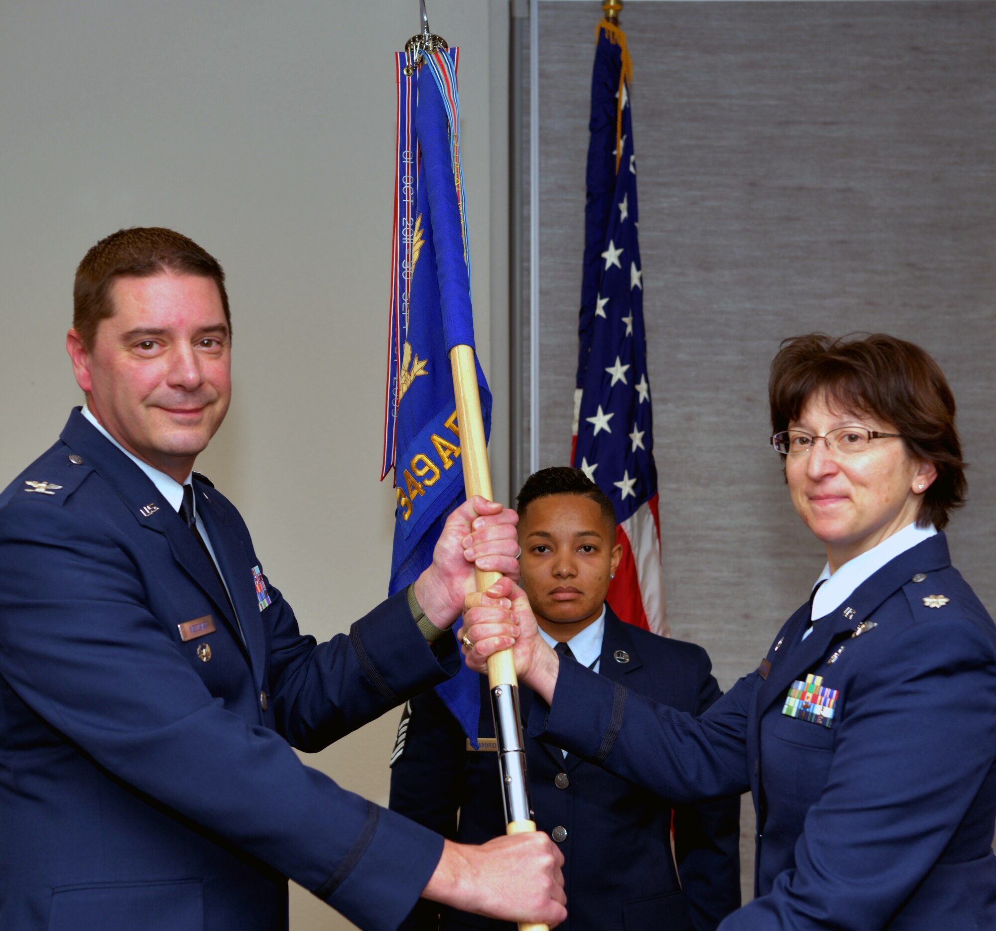 Lt. Col. Erin Hutchison, 349th Aeromedical Evacuation Squadron commander, recieves the guidon from Col. Charles Metzger, 349th Air Mobility Wing vice commander, during an assumption command ceremony on Dec. 8, 2018, at Travis Air Force Base, Calif.
