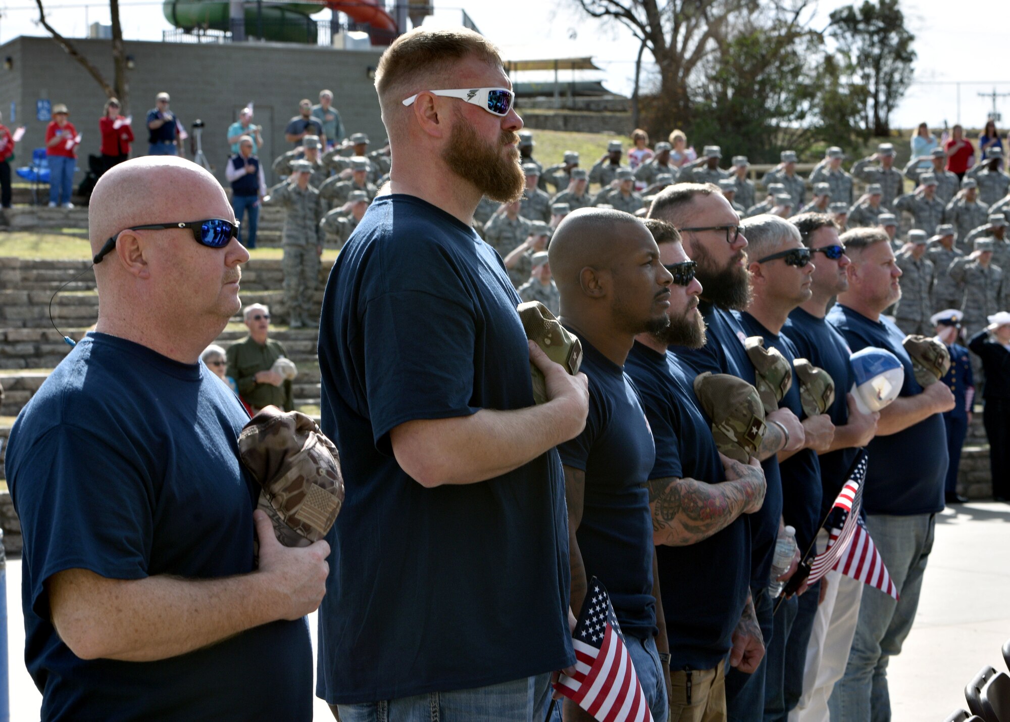 San Angelo Support for Veterans participants stand for the playing of the National Anthem during the San Angelo Support for Veterans Honor Ceremony at the Bill Aylor Sr. Memorial Riverstage in San Angelo, Texas, Dec. 5, 2019. After being honored at the ceremony, the veterans set off for a weekend of hunting and camaraderie. (U.S. Air Force photo by Airman 1st Class Robyn Hunsinger)