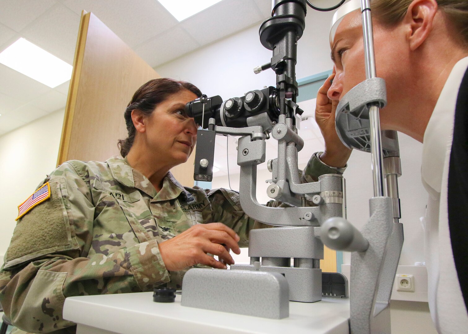Col. Adrienne Ari, an optometrist at Landstuhl Regional Medical Center in Germany, performs an eye examination Sept. 19, 2019. In October 2018, the Army, Navy and Air Force started the process to transfer the administration and management of their military medical treatment facilities to DHA. Phase II of that transition was completed this fall with roughly half of the MTFs in the continental U.S. now under the DHA. All other hospitals and clinics, including those overseas, will follow suit by 2021.