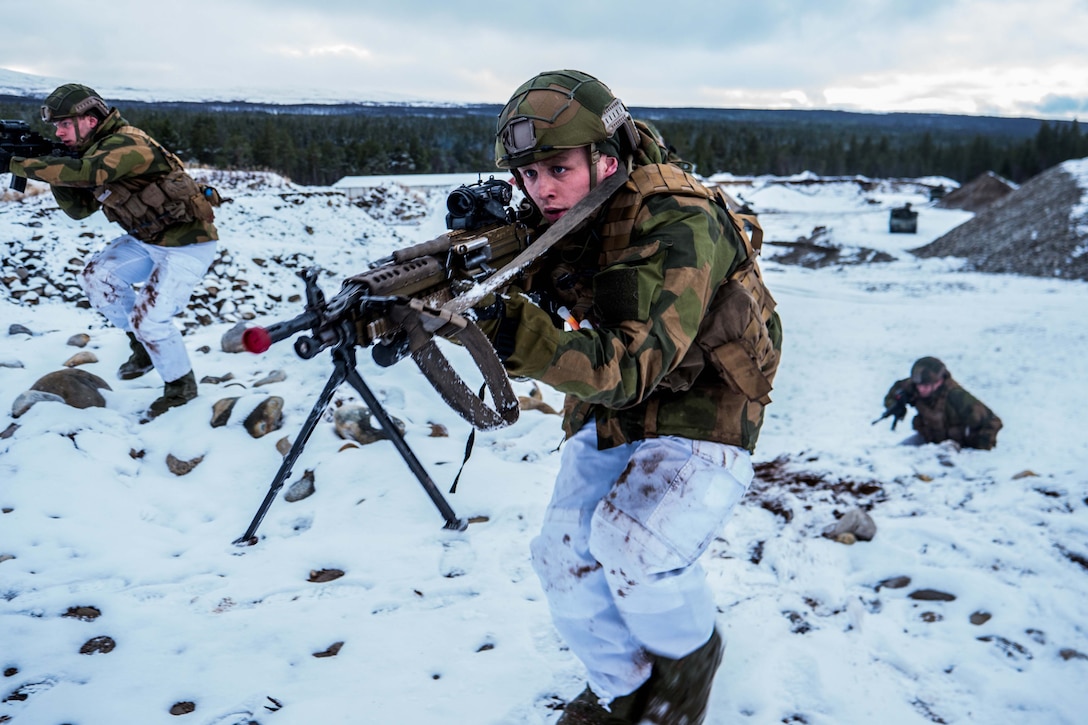 Soldiers with weapons advance in snow.