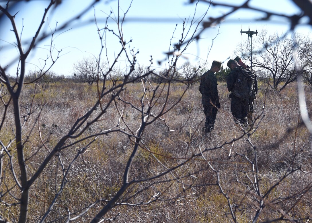 U.S. Marine Corps Detachment students huddle together to reorient themselves to the directions suggested by their versatile radio observation and direction finder, compass and map during a field exercise outside of the MCD on Goodfellow Air Force Base, Texas, Dec. 6, 2019. Goodfellow stresses hands-on educational advances into its training curriculum, which is in line with the National Defense Strategy. (U.S. Air Force Photo by Airman 1st Class Abbey Rieves)