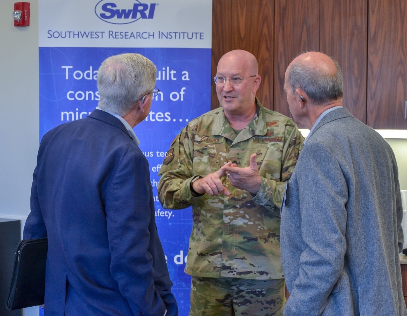 Lt. Col. Eddie K. Stamper (center), Joint Base San Antonio-Electromagnetic Defense Initiative project officer, speaks with J.O. McFalls, McFalls Associates LLC, and Klaus Weiswurm, Innovation Technology Machinery chairman and an appointee to the U.S. Air Force Civic Leader Program, before the quarterly San Antonio Electromagnetic Defense meeting at Southwest Research Center Nov. 18.