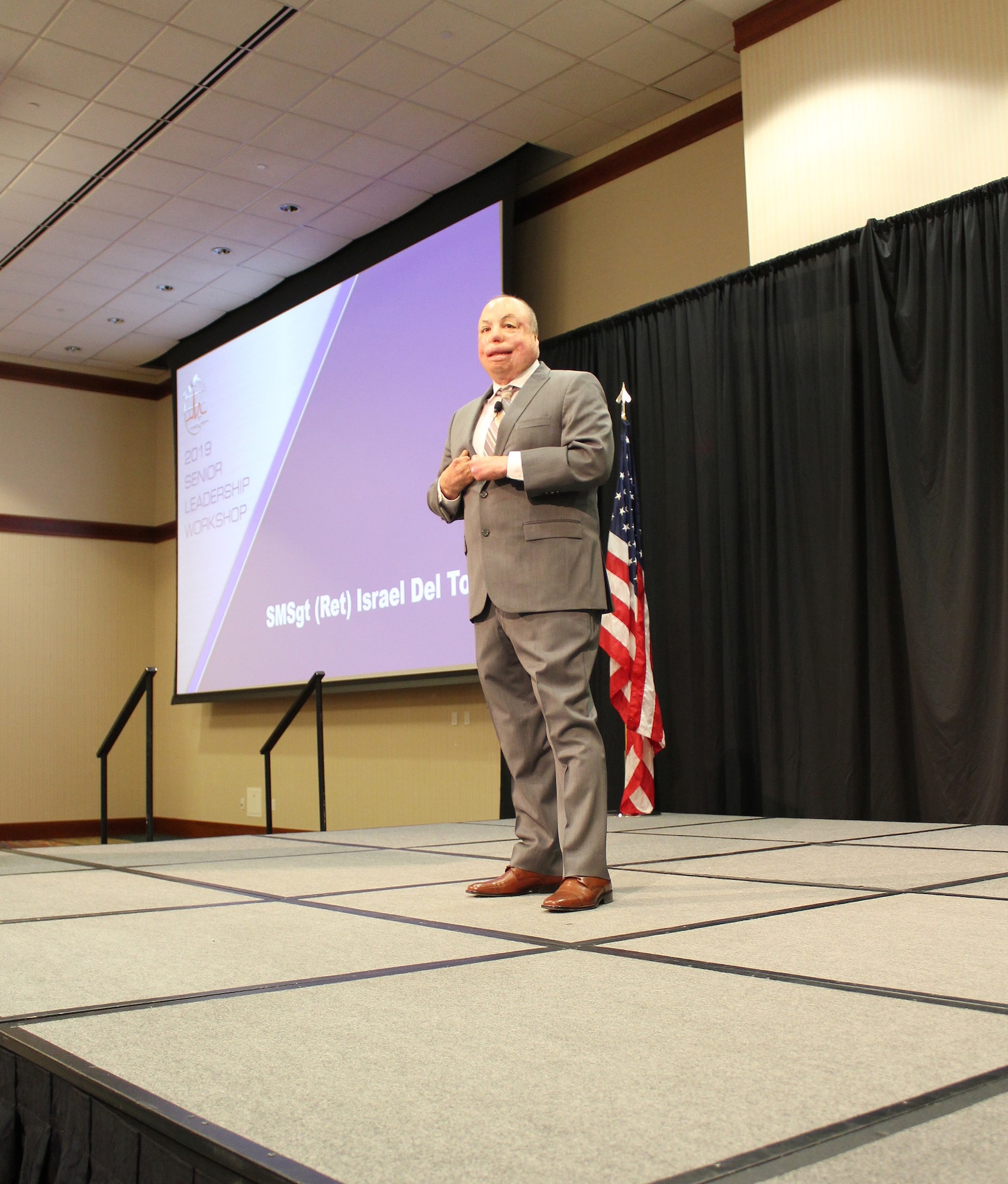 U.S. Air Force Senior Master Sgt. (Ret) Israel Del Toro speaks at the at the Air Force Medical Service 2019 Senior Leadership Workshop in Leesburg, Virginia, Dec. 4, 2019. Fourteen years ago, Del Toro was injured in a blast that caused third degree burns on 80% of his body. Del Toro shared how his burns made him stronger. “Every time I got knocked down, I didn’t get up on my own. I had teammates who were there to help me back up,” said Del Toro. (U.S. Air Force photo by Josh Mahler)