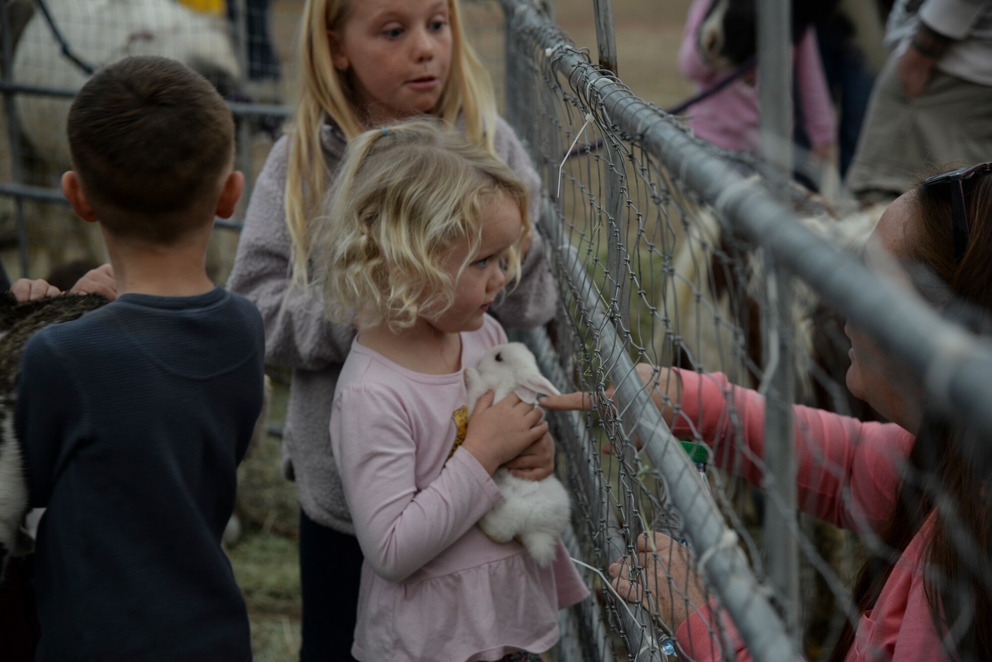 a photo of A child holding a bunny during a base holiday event.