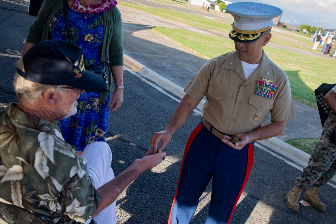 U.S. Marine Corps Col. Raul Lianez, commanding officer, Marine Corps Base Hawaii, gives Mr. Daniel Griffin, a veteran whose father was present during the attack on Naval Air Station Kaneohe Bay, casings from the 21-gun salute after the annual Klipper Ceremony, Marine Corps Base Hawaii, Dec. 7, 2019. The Klipper Memorial was dedicated in 1981 to honor the 17 U.S. Navy Sailors and two civilian contractors who died during the attack on Naval Air Station Kaneohe Bay on Dec. 7, 1941.