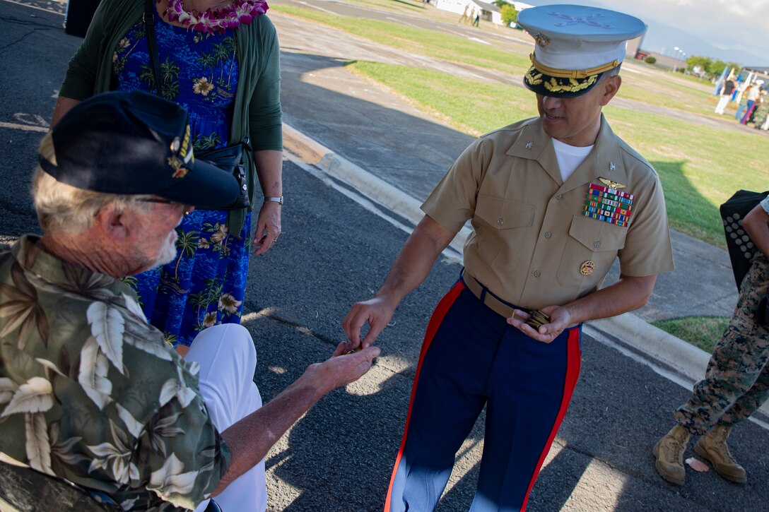 U.S. Marine Corps Col. Raul Lianez, commanding officer, Marine Corps Base Hawaii, gives Mr. Daniel Griffin, a veteran whose father was present during the attack on Naval Air Station Kaneohe Bay, casings from the 21-gun salute after the annual Klipper Ceremony, Marine Corps Base Hawaii, Dec. 7, 2019. The Klipper Memorial was dedicated in 1981 to honor the 17 U.S. Navy Sailors and two civilian contractors who died during the attack on Naval Air Station Kaneohe Bay on Dec. 7, 1941.