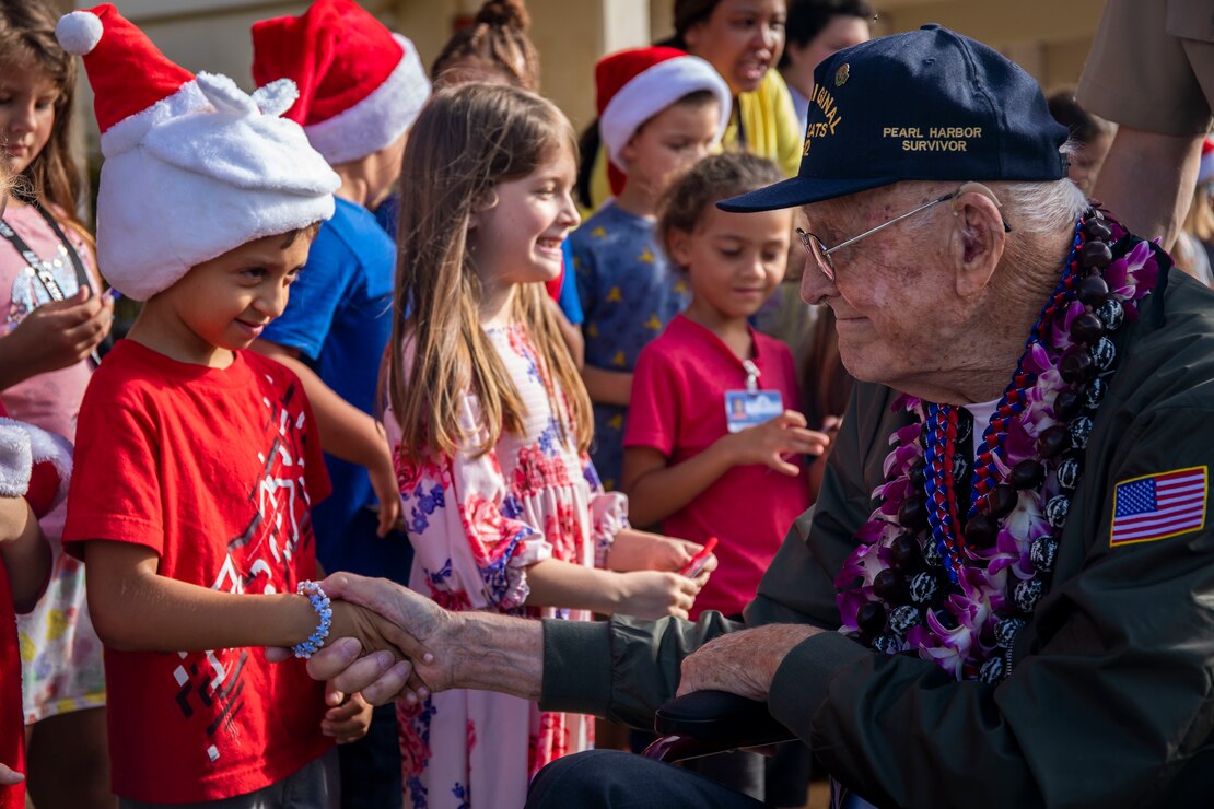 Donald Long, retired U.S. Navy radio operator, shakes a student with Mokapu Elementary School's hand during his visit to Marine Corps Base Hawaii, Dec. 5, 2019. The Best Defense Foundation returned 6 WWII Pearl Harbor and Naval Air Station Kaneohe Bay survivors to Hawaii for the 78th Commemoration of Pearl Harbor and Naval Air Station Kaneohe Bay which is now MCBH. The heroes returned were Jack Holder US NAVY - Naval Air Station, Kaneohe Bay; Tom Foreman US Navy - USS Cushing; Ira Schab US Navy - USS Dobbin; Stuart Hedley US Navy - USS West Virginia; Donald Long US Navy - Naval Air Station, Kaneohe Bay; and Chuck Kohler US Navy - USS Hornet.