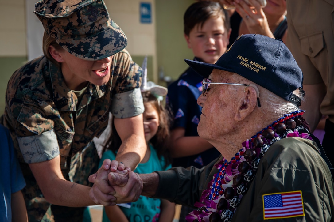 Donald Long, retired U.S. Navy radio operator, shakes a U.S. Marine's hand during his visit to Marine Corps Base Hawaii , Dec. 5.