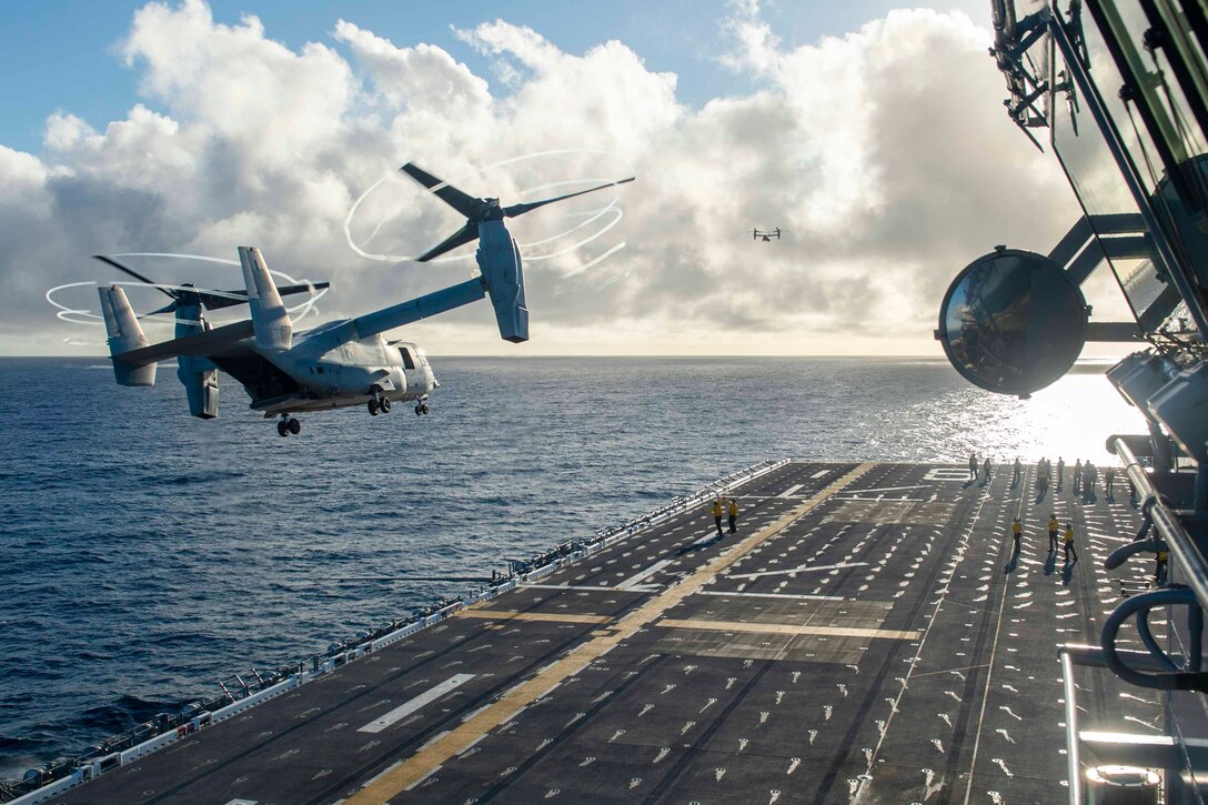 A plane flies next to a ship.