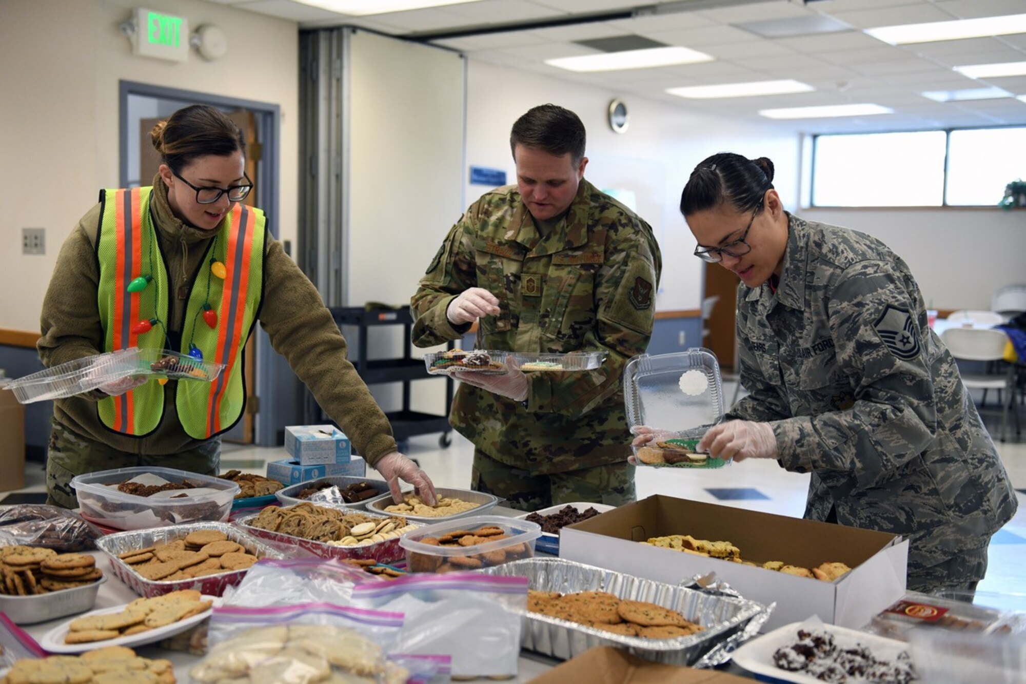 2nd Lt. Kassidi Nudd, Chief Master Sgt. Paul Strazz, and Master Sgt. Jenipher Sears package cookies during the 419th Fighter Wing's annual Cookies for Airmen project