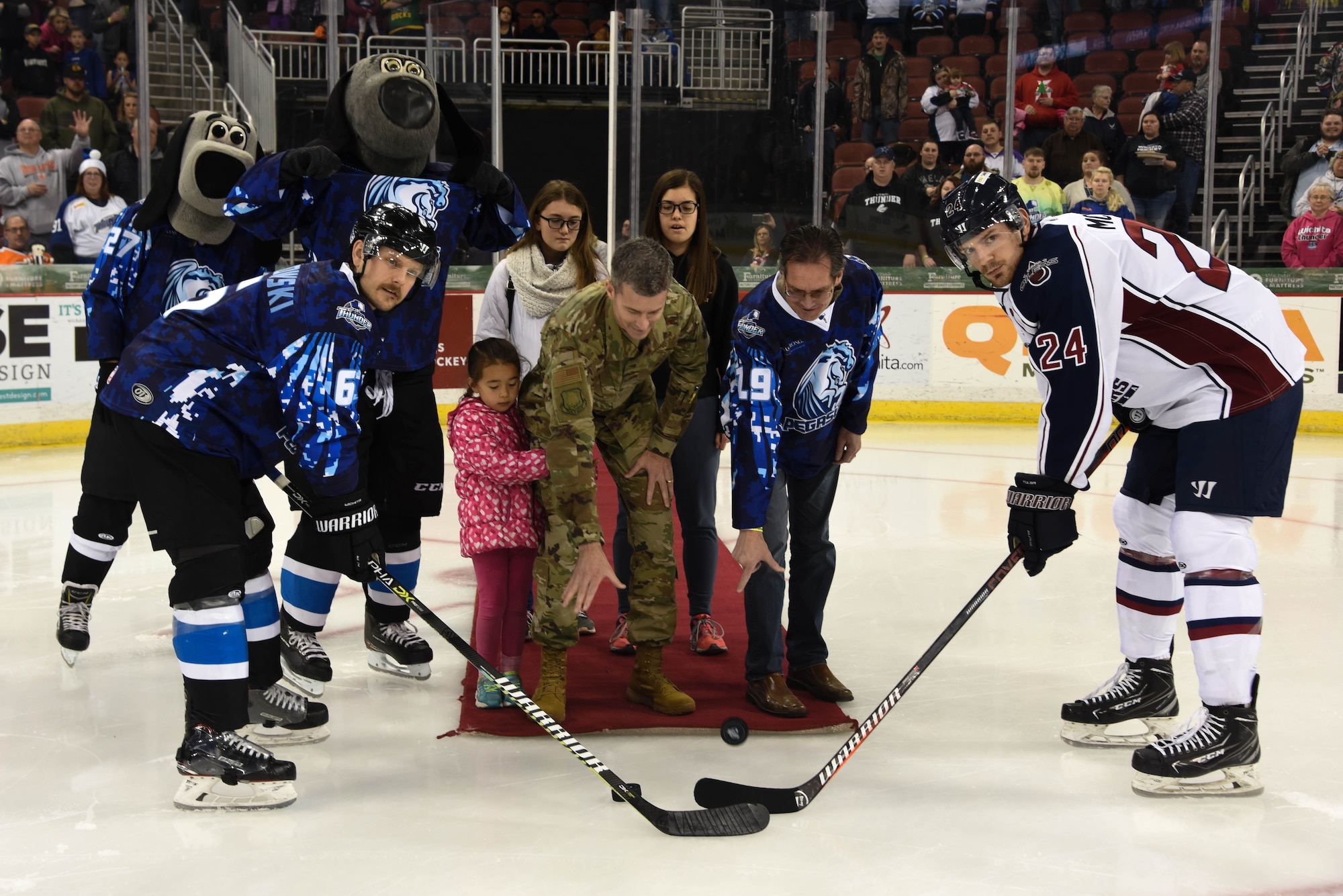 Col. Rich Tanner, 22nd Air Refueling Wing commander, and Warren Martin, Kansas Strong executive director, drop a ceremonial puck before the beginning of a hockey game between the Wichita Thunder and the Tulsa Oilers at INTRUST Bank Arena Dec. 7, 2019, in Wichita, Kan. The Wichita Thunder honored the 22nd ARW by wearing a specially designed jersey with camouflage and a Pegasus logo for Military Appreciation Night. (Air Force photo by Airman 1st Class Marc A. Garcia)