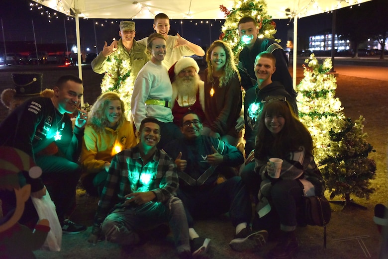Students on Goodfellow take a photo with Santa during the Tree Lighting event on the parade field at Goodfellow Air Force Base, Texas, Dec. 6, 2019. After visiting with Santa, individuals were able to drink hot chocolate, hot apple cider and decorate ornaments and cookies. (U.S. Air Force photo by Senior Airman Seraiah Wolf)