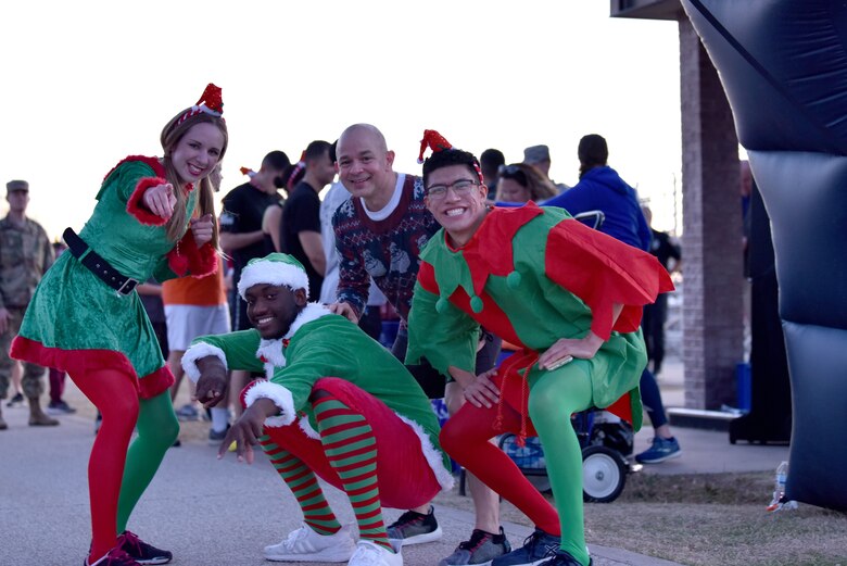 Col. Andres Nazario, 17th Training Wing commander, poses with participants in the Jingle Bell 5K held on Goodfellow Air Force Base, Texas, Dec. 6, 2019. Members were able to participate in the run before the rest of the events at the Christmas Tree Lighting ceremony. (U.S. Air Force photo by Senior Airman Seraiah Wolf)
