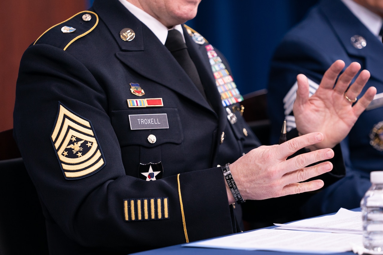 Service member gestures while speaking and wearing the new rank insignia for the military’s top enlisted position. The chevron features an eagle and four stars in the center.