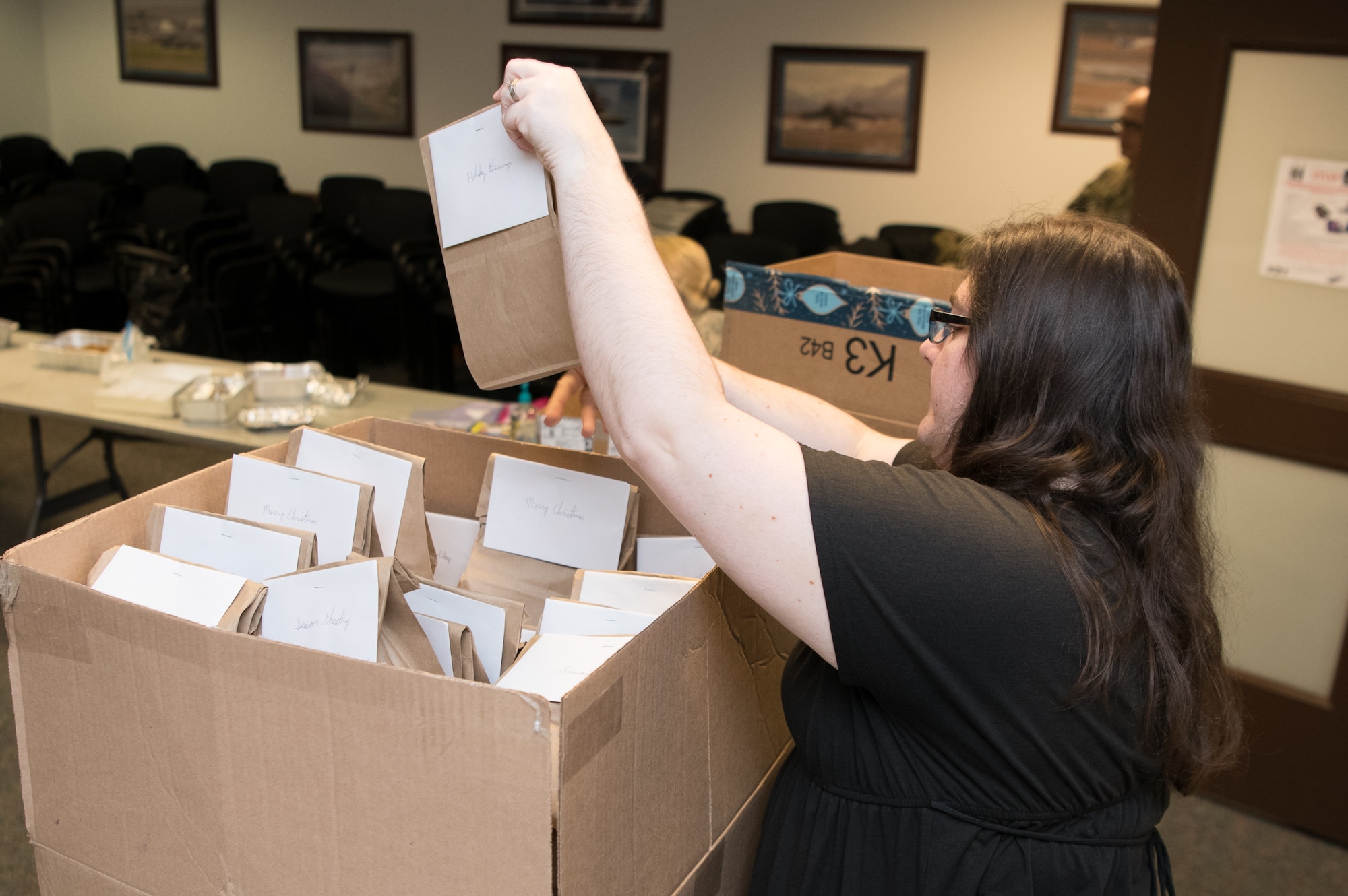 Lauren Morgan loads a box with bags of cookies and baked goods during Operation Cookie Drop
Dec. 9, 2019, at the 9th Airlift Squadron on Dover Air Force Base, Del. Leaders from each squadron will deliver the cookies to their Airmen living in the dormitories. (U.S. Air Force photo by Mauricio Campino)