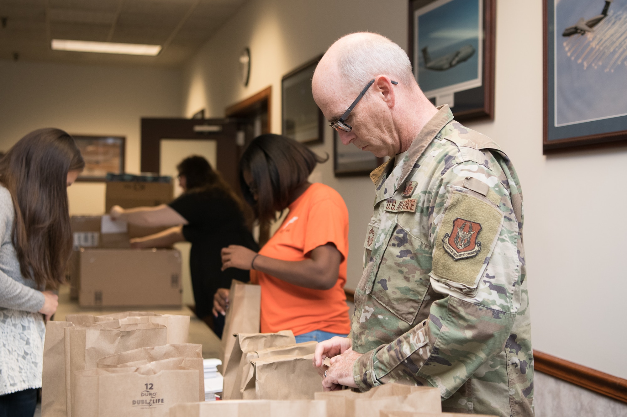 Chief Master Sgt. Bryan Ford, 512th Maintenance Squadron, closes paper bags filled with cookies and baked goods during Operation Cookie Drop Dec. 9, 2019, at the 9th Airlift Squadron on Dover Air Force Base, Del.  The Dover Chiefs’ Group has organized the event for the last 17 years. (U.S. Air Force photo by Mauricio Campino)