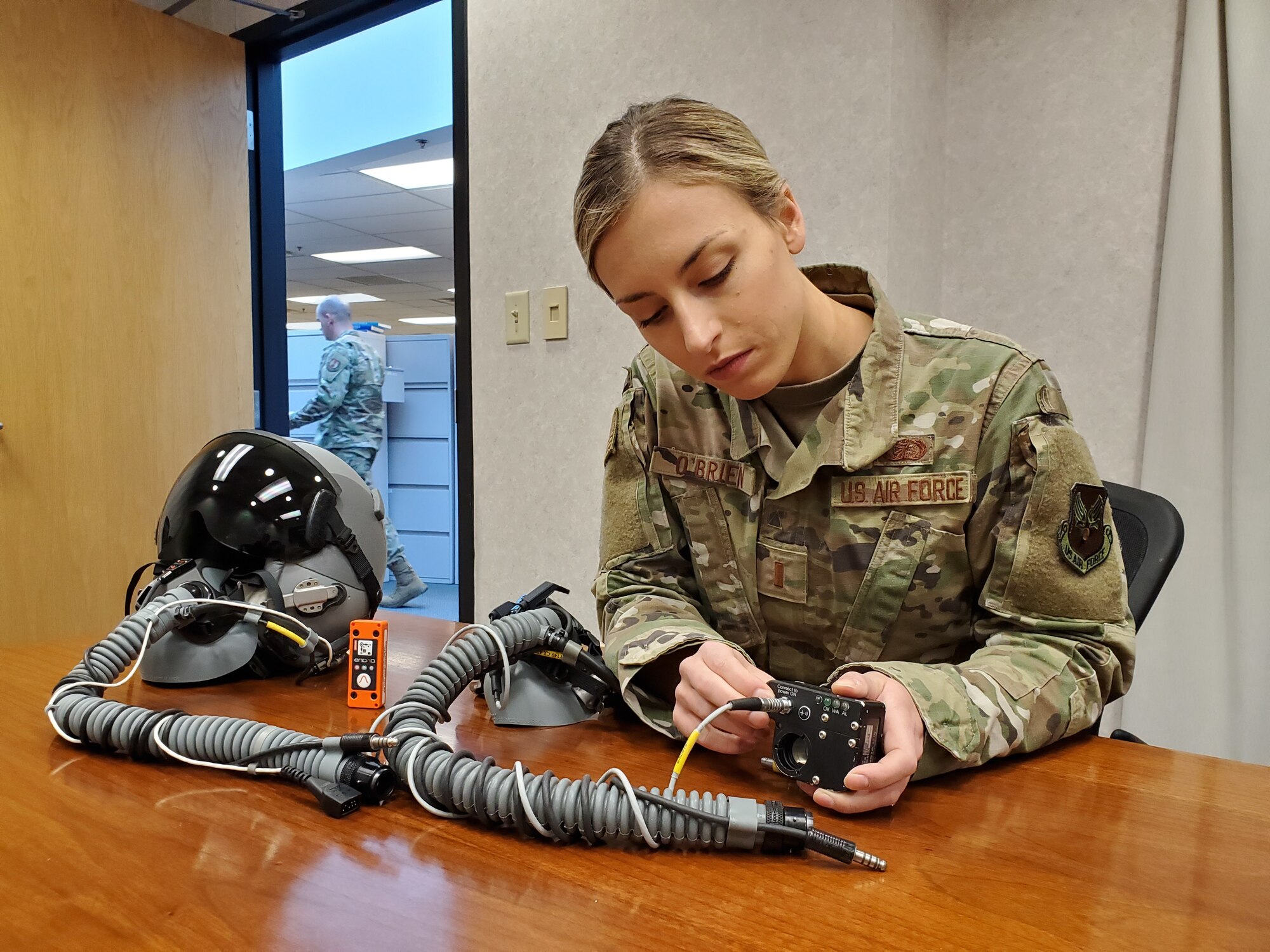 2nd Lt. (Dr.) Dominique O’Brien, Project Lead, Airman Sensing and Assessment Product Line, with the 711th Human Performance Wing’s Airman Systems Directorate, displays two devices her team used during flight tests in support of a request from the 20th Fighter Wing to provide assistance with assessing cabin pressure, oxygen concentrations, and possible hypoxia-like symptoms reported by their F-16 pilots. One device is called the “Slam Stick,” (orange in color), which measures tri-axial acceleration – or acceleration in all three axes, X, Y, and Z. The second device is called the Insta Pilot Breath Air Monitor, or IPBAM, (black device being held by Lt. O’Brien) which measures several critical parameters of the breathing gas delivered to the pilot. (U.S. Air Force photo/Bryan Ripple)