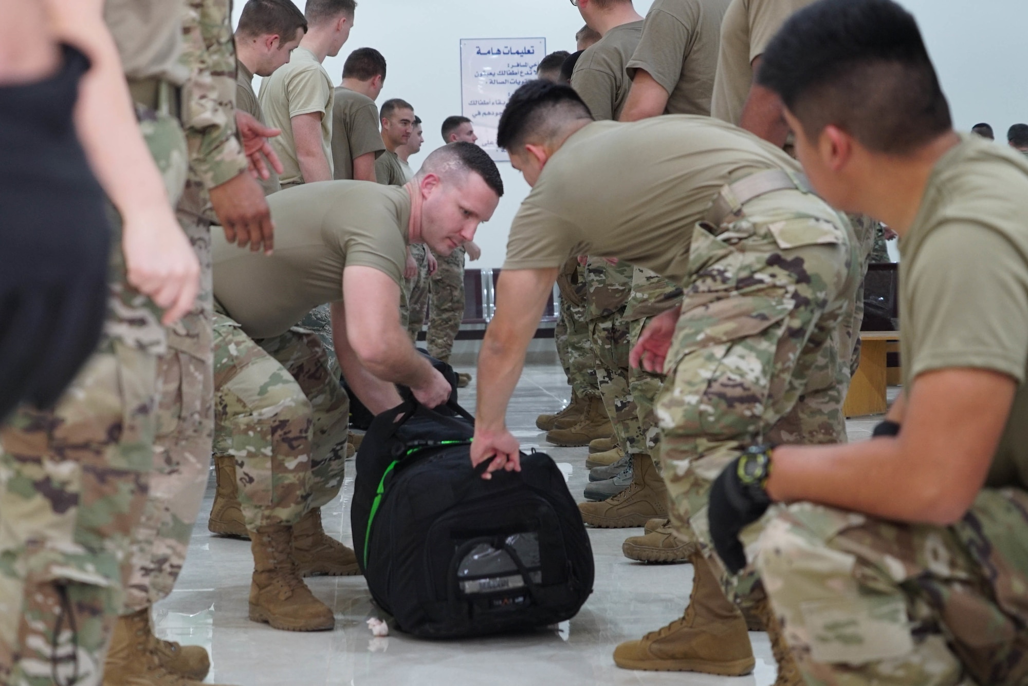 U.S. Airmen work together to unload baggage from a deployment rotation on Prince Sultan Air Base (PSAB), Saudi Arabia, Nov. 26, 2019.