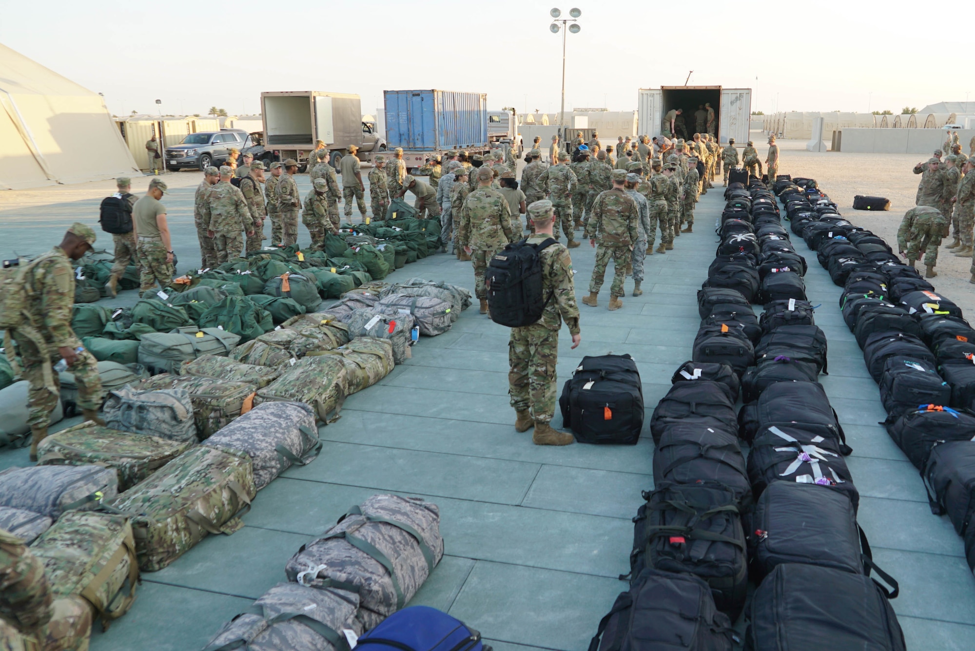 U.S. Airmen finish unloading a baggage truck and begin the process of finding their bags on Prince Sultan Air Base (PSAB), Saudi Arabia, Nov. 26, 2019.