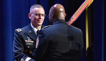 Lt. Gen. Daniel L. Karbler, commanding general, U.S. Army Space and Missile Defense Command, passes the command colors to USASMDC Command Sgt. Maj. Finis Dodson during a Change of Command conducted at the Von Braun III auditorium on Redstone Arsenal, Alabama, Dec. 6, 2019. Karbler assumed command of SMDC as well as the Joint Functional Component Command for Integrated Missile Defense during the ceremony. (U.S. Army photo by Cecil Longino)