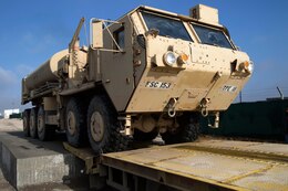 Staff Sgt. Victor Cardona, movement noncommissioned officer, 103rd Expeditionary Command, loads an M1074 Palletized Loading System onto a trailer at the Syrian Logistics Cell operations center, Erbil, Iraq, Dec. 3, 2019. Once the vehicle is loaded, it will be delivered to Syria.