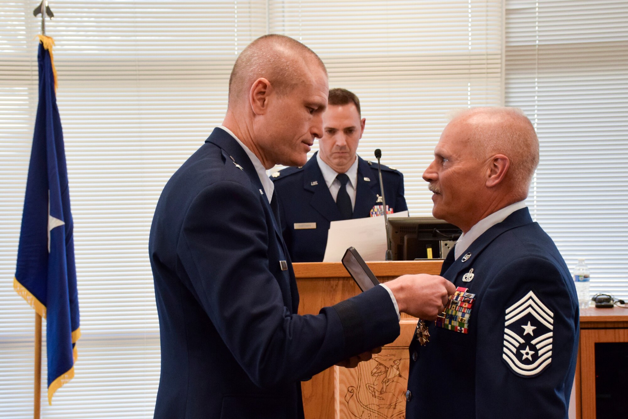 Brig. Gen. Shawn Ford (left), Deputy Adjutant General for Air, Iowa National Guard, presents Chief Master Sgt. Timothy E. Cochran (right), former Command Chief Master Sgt. (CCM) of the Iowa Air National Guard, with the Legion of Merit award during his retirement ceremony held in the dining facility of the 132d Wing in Des Moines, Iowa on Saturday, December 7, 2019.  Cochran is the 6th CCM of Iowa and has served the state and Air Guard for over thirty-eight years.  (Air National Guard photo by Tech. Sgt. Linda K. Burger/Released)