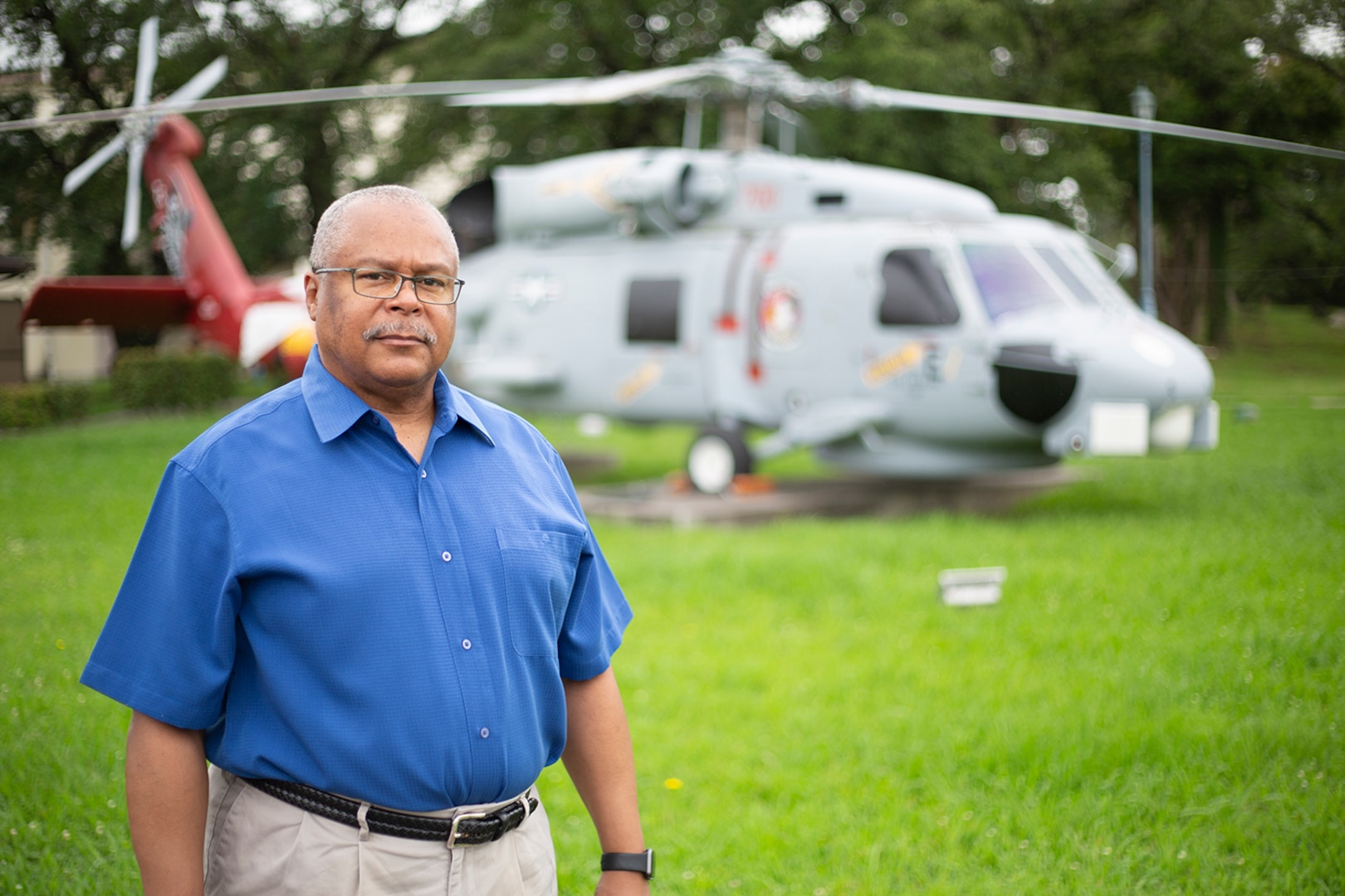Man stands in front of helicopter.