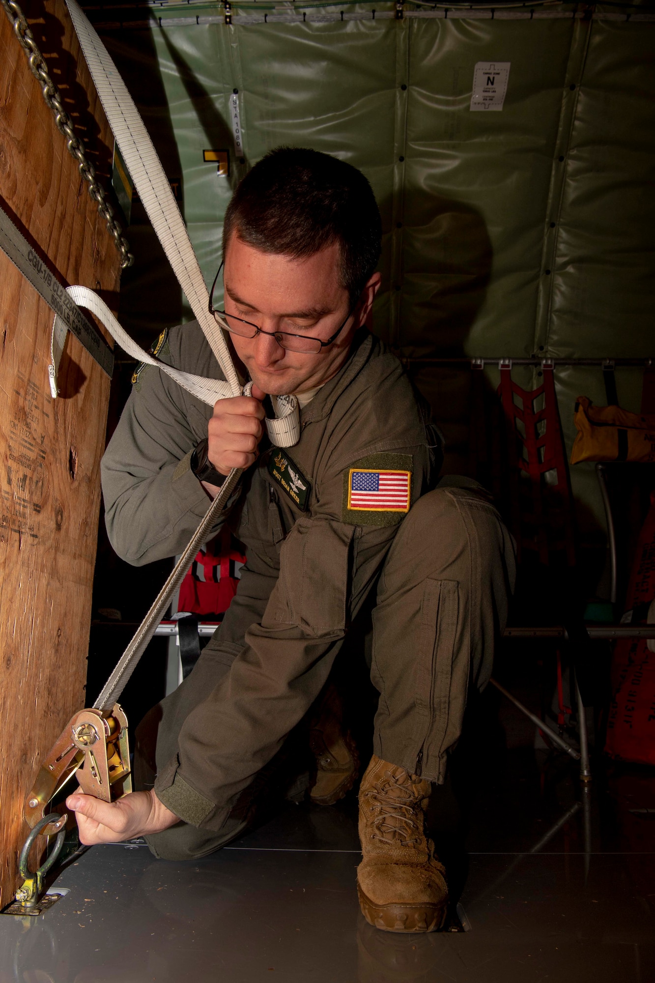 U.S. Air Force Master Sgt. Brian Greer, a 77 ARS boom operator, secures loose cargo on a KC-135 Stratotanker before takeoff from the flightline on Seymour Johnson Air Force Base, North Carolina, Dec. 5, 2019.