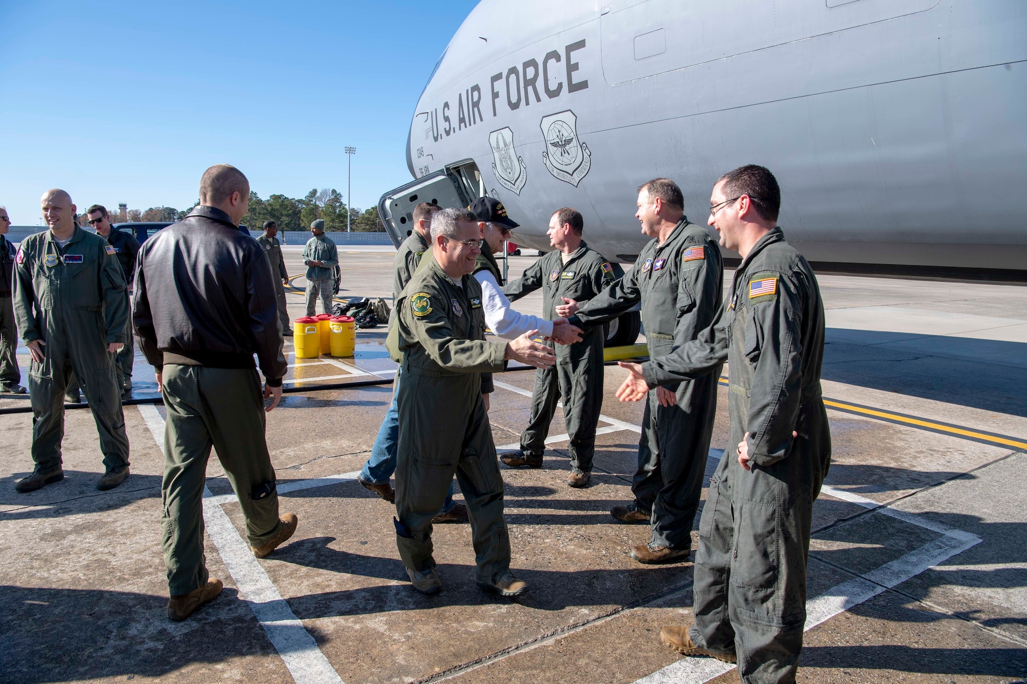 U.S. Air Force Lt. Col. Doug Miller and Lt. Col. Joe Smarsh, 77th Air Refueling Squadron pilots, along with Master Sgt. Brian Greer, a 77 ARS boom operator, greet friends, family, and peers on the flightline at Seymour Johnson Air Force Base, North Carolina, Dec. 5, 2019.