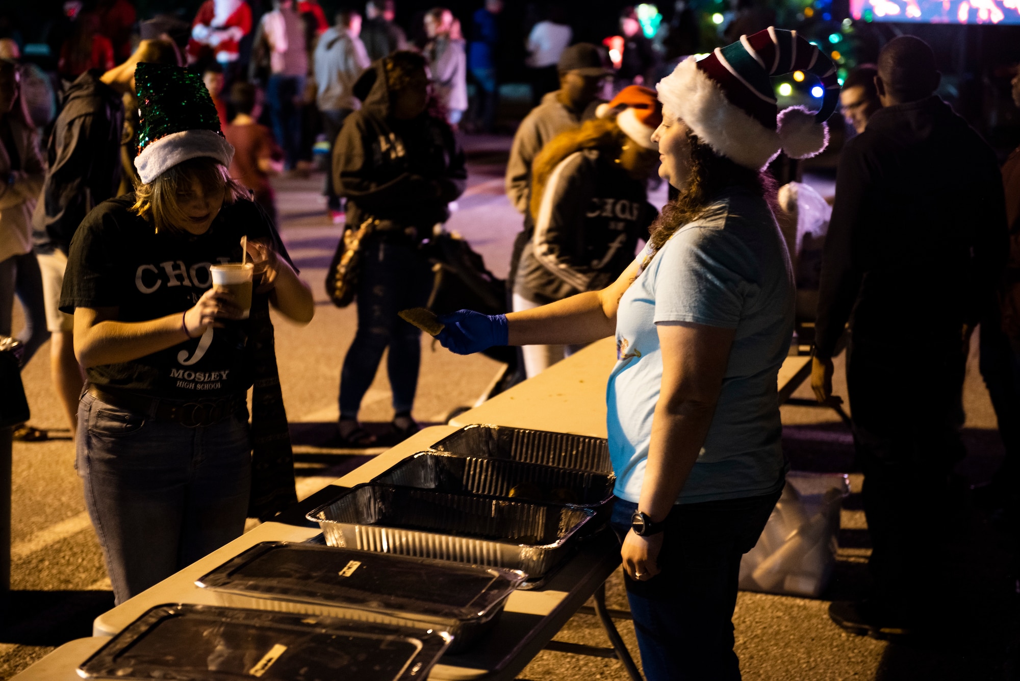 A volunteer offers a cookie to an event attendee at the 325th Force Support Squadron holiday tree lighting ceremony at Tyndall Air Force Base, Florida, Dec. 6, 2019. The annual event was held at the base's Oasis Event Center, and was attended by service members, their spouses, dependents, local students and retirees. (U.S. Air Force photo by Staff Sgt. Magen M. Reeves)