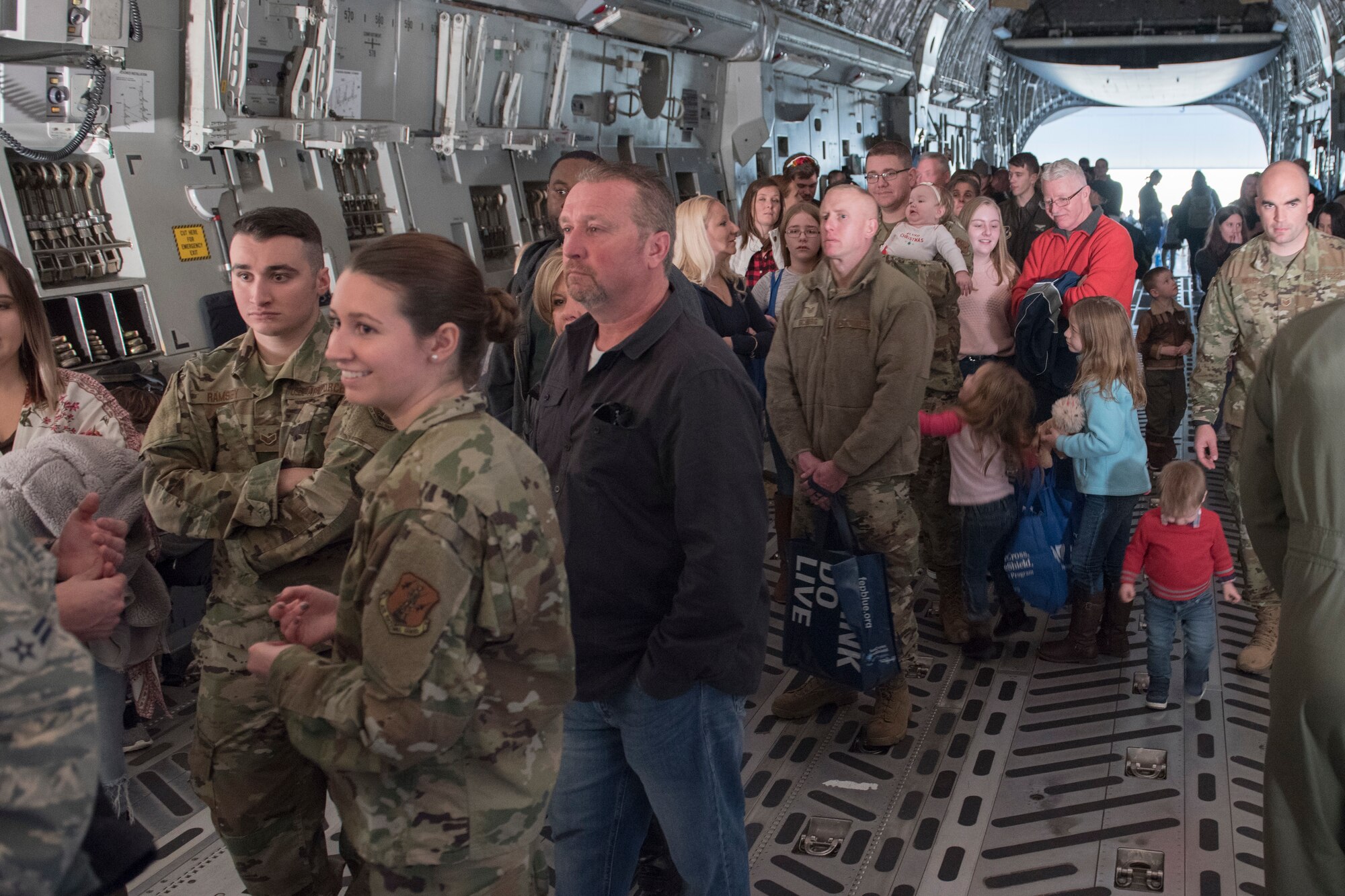 Airmen and their families wait in line to see the cockpit of a C-17 Globemaster III aircraft as part of the 167th Airlift Wing family day event, Dec. 8, 2019
