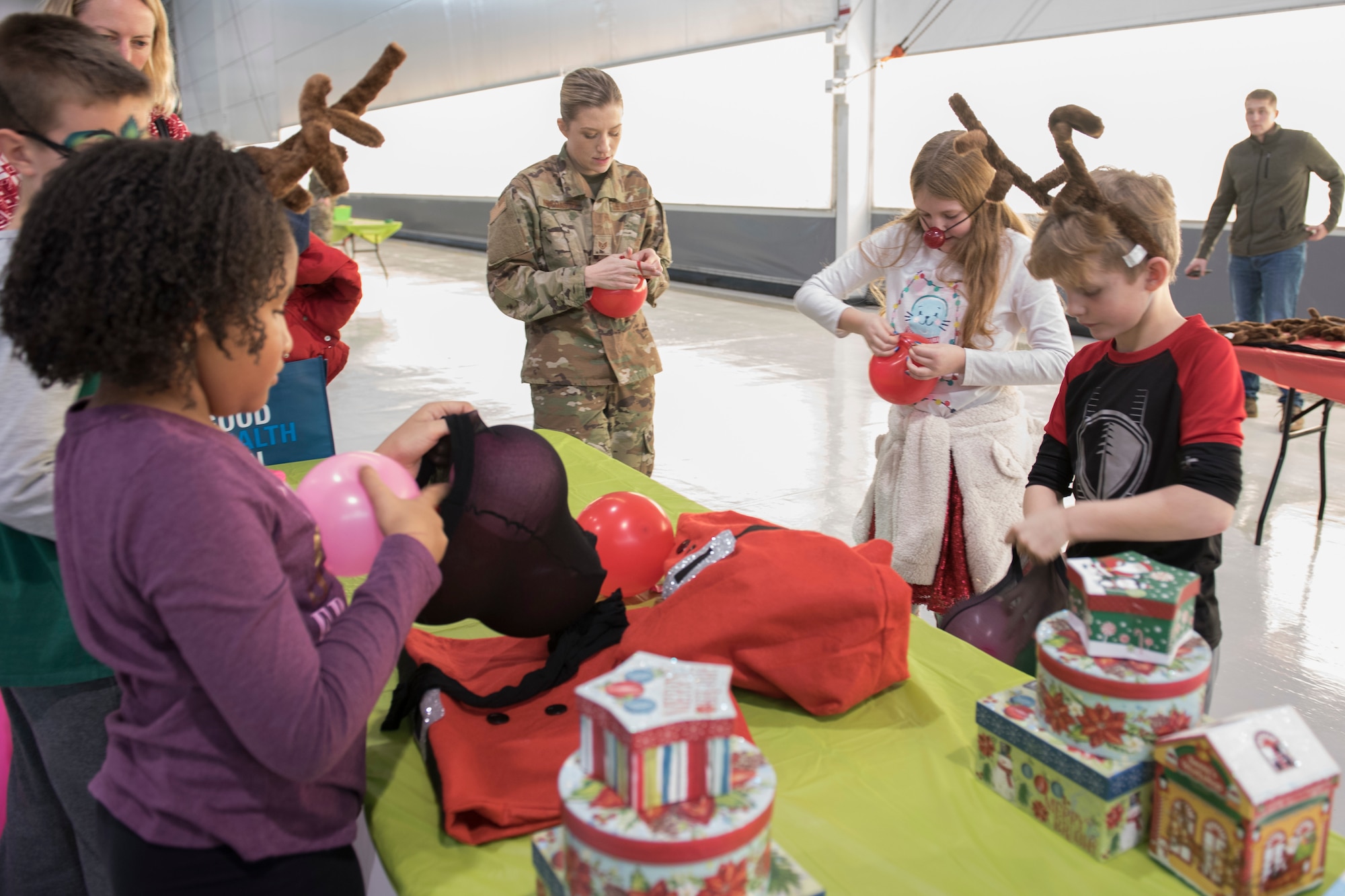 Children blow up balloons as part of the reindeer games competition during the 167th Airlift Wing family day event, Dec. 8, 2019