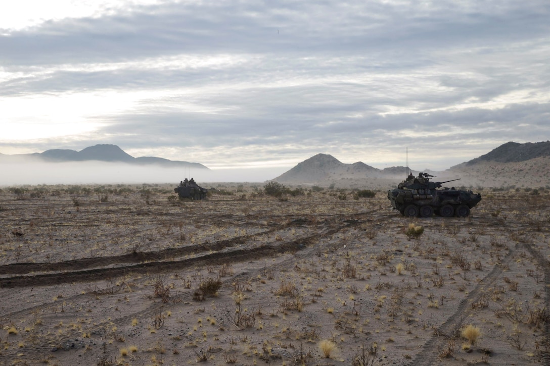 Two tanks travel in the desert.