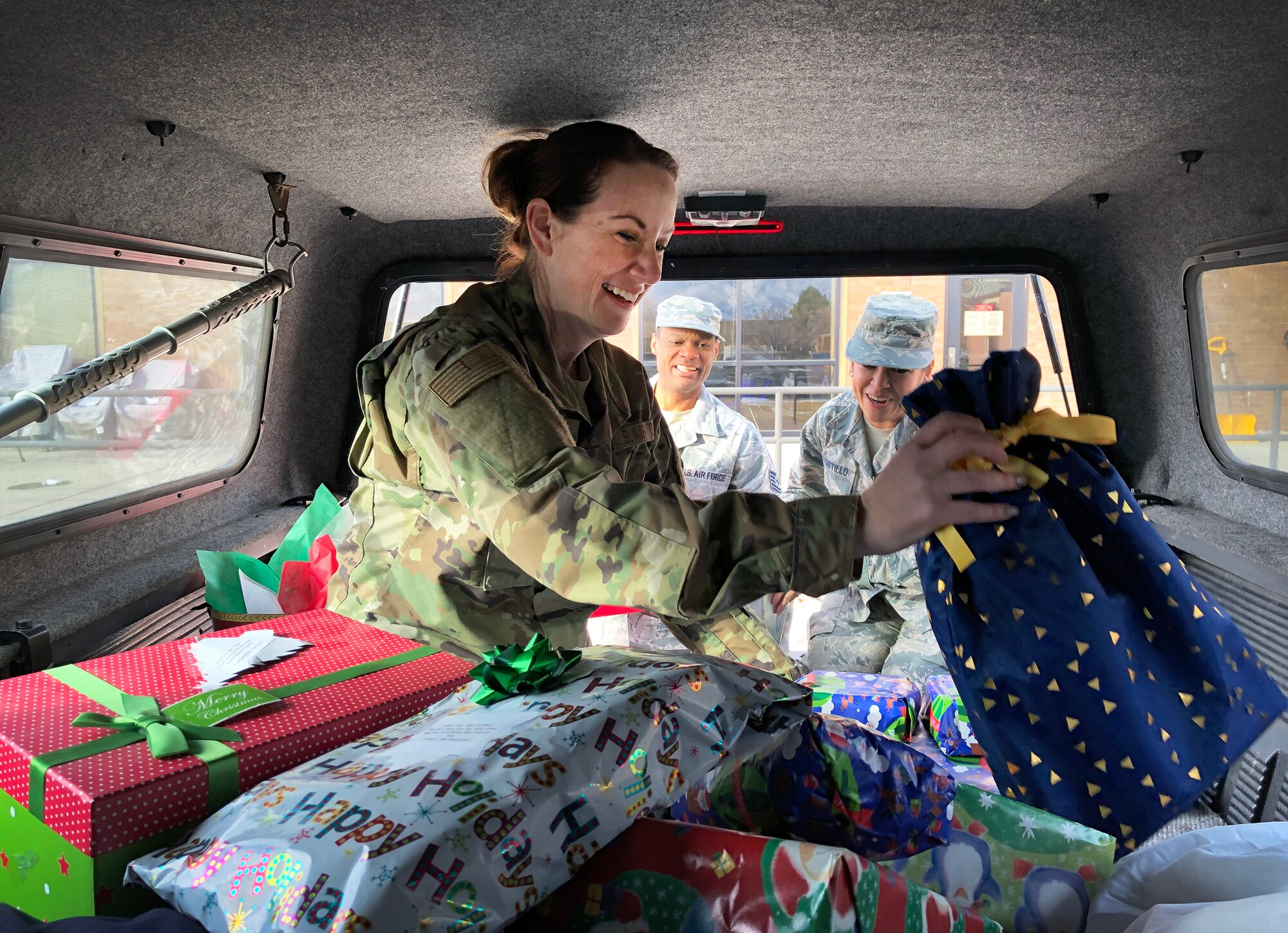 Senior Master Sgt. Michelle Corlett, Tech. Sgt. Marick Myles, and Tech. Sgt. Beryl Castillo, all reservists in the 419th Fighter Wing, load a truck full of toys to be delivered to a local Utah family as part of holiday charity event