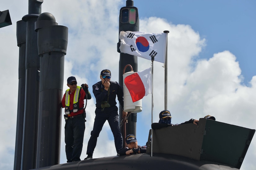 People work on the deck of a submarine.