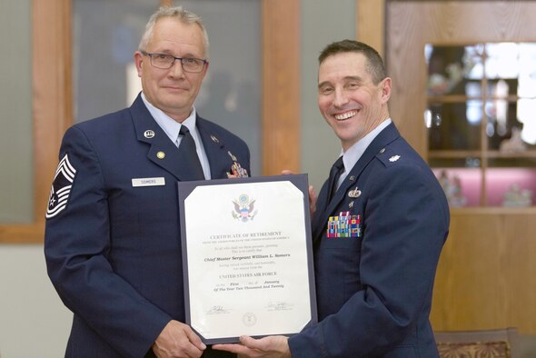 Lt. Col. Scott Uselding, 434th Force Support Squadron commander, presents Chief Master Sgt. Will Somers with his certificate of retirement at Grissom Air Reserve Base, Ind., Dec. 7, 2019. Somers hung up his uniform after 33 years of military service, but continues to serve Grissom as a civilian. (U.S. Air Force photo / Airman 1st Class Harrison Withrow)