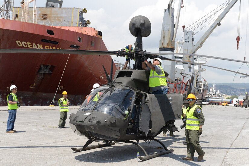 An OH-58D Kiowa Warrior helicopter, part of an Excess Defense Articles grant, is unloaded May 16 at the Greek port city of Volos.