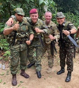 New York Army National Guard Staff Sgt. Thomas Carpenter, second from right, and other Soldiers who graduated from the Jungle Operations International Course conducted by the Brazilian Army Jungle Warfare Training Center, brandish their machetes following a graduation ceremony Nov. 30, 2019, in Manaus, Brazil. Carpenter was the 30th American Soldier to graduate from the demanding course.