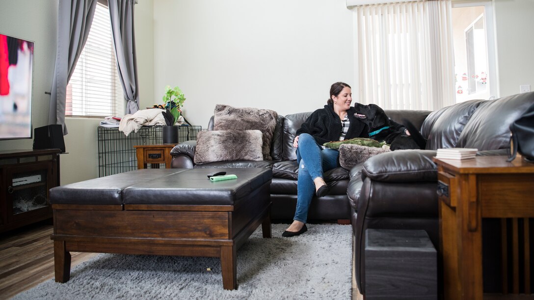 Emily Dreiling, 30th Space Wing sexual assault prevention and response coordinator, and Preston, 30th SW courthouse facility dog, sit on their couch at home after work in Guadalupe, Calif., Dec. 5, 2019. Dreiling requested to receive Preston as a part of her family and work team at the Sexual Assault Prevention and Response office in 2017 from the Tender Loving Canines Assistance Dogs, where she then had to go and receive distinct training on how to handle this SAPR-K9. (U.S. Air Force photo by Airman 1st Class Aubree Milks)