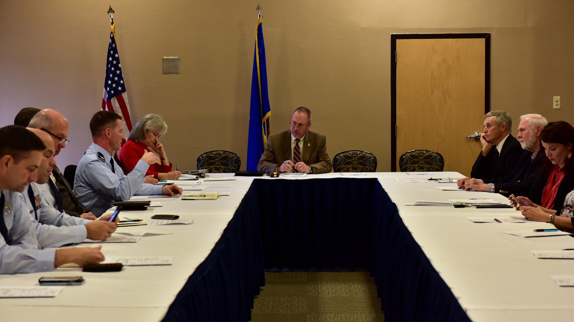 Individuals gather in a room for a meeting