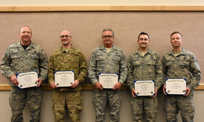 Community College of the Air Force graduates are photographed with their diplomas after a graduation ceremony at Whiteman Air Force Base, Mo., Dec. 8, 2019.