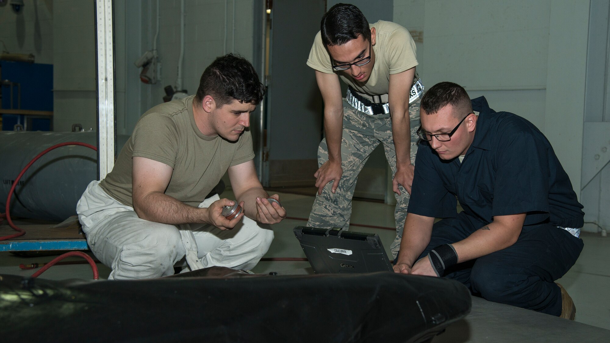 Sixth Maintenance Squadron (MXS) fuels system technicians review a technical order for sealing a fuel cell bladder at MacDill Air Force Base, Fla., Nov. 25, 2019.