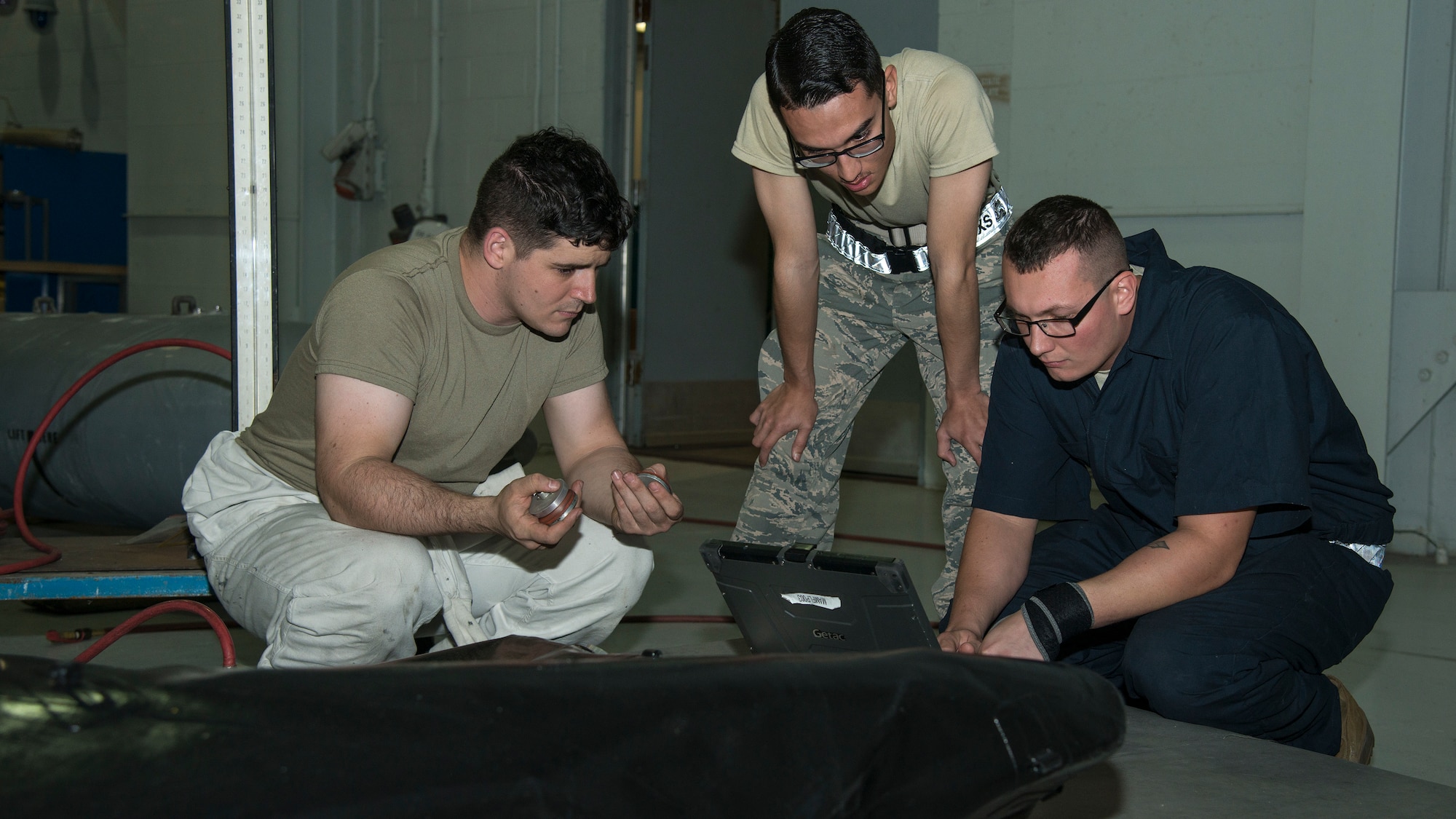 Sixth Maintenance Squadron (MXS) fuels system technicians review a technical order for sealing a fuel cell bladder at MacDill Air Force Base, Fla., Nov. 25, 2019.