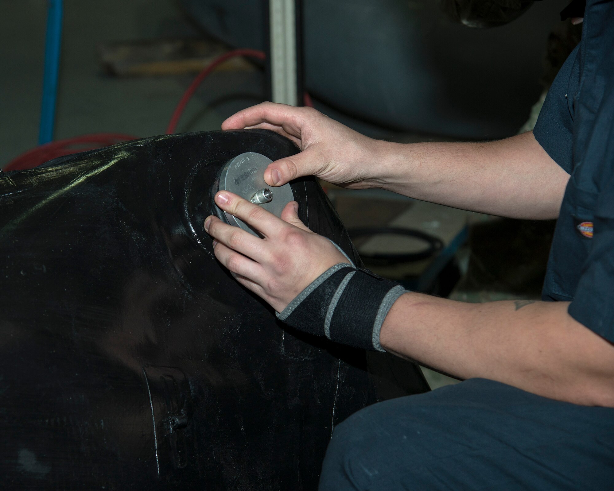 U.S. Air Force Staff Sgt. Dakota Williamson, a 6th Maintenance Squadron (MXS) fuels system craftsman, affixes a metal plate to seal a fuel cell bladder at MacDill Air Force Base, Fla., Nov. 25, 2019.