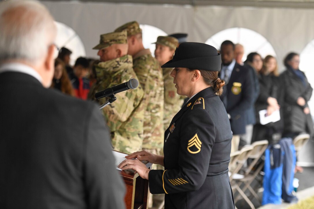 Staff Sgt. Tracy Thomas, Delaware Army National Guard, sings during a Wreaths Across America (WAA) event in Dover, Del., Dec. 9, 2019. During the Dover WAA event, many local and military leaders spoke before joining children from a local elementary school to place wreaths at each of the memorials located around Legislative Mall. The annual WAA event is held at more than 1,600 locations, where volunteers lay wreaths at memorials and cemeteries in honor of those who served. The wreaths are symbolic: the evergreens represent longevity and endurance, the red bow represents great sacrifice, and the circular shape represents eternity. (U.S. Air Force photo by Senior Airman Eric M. Fisher)