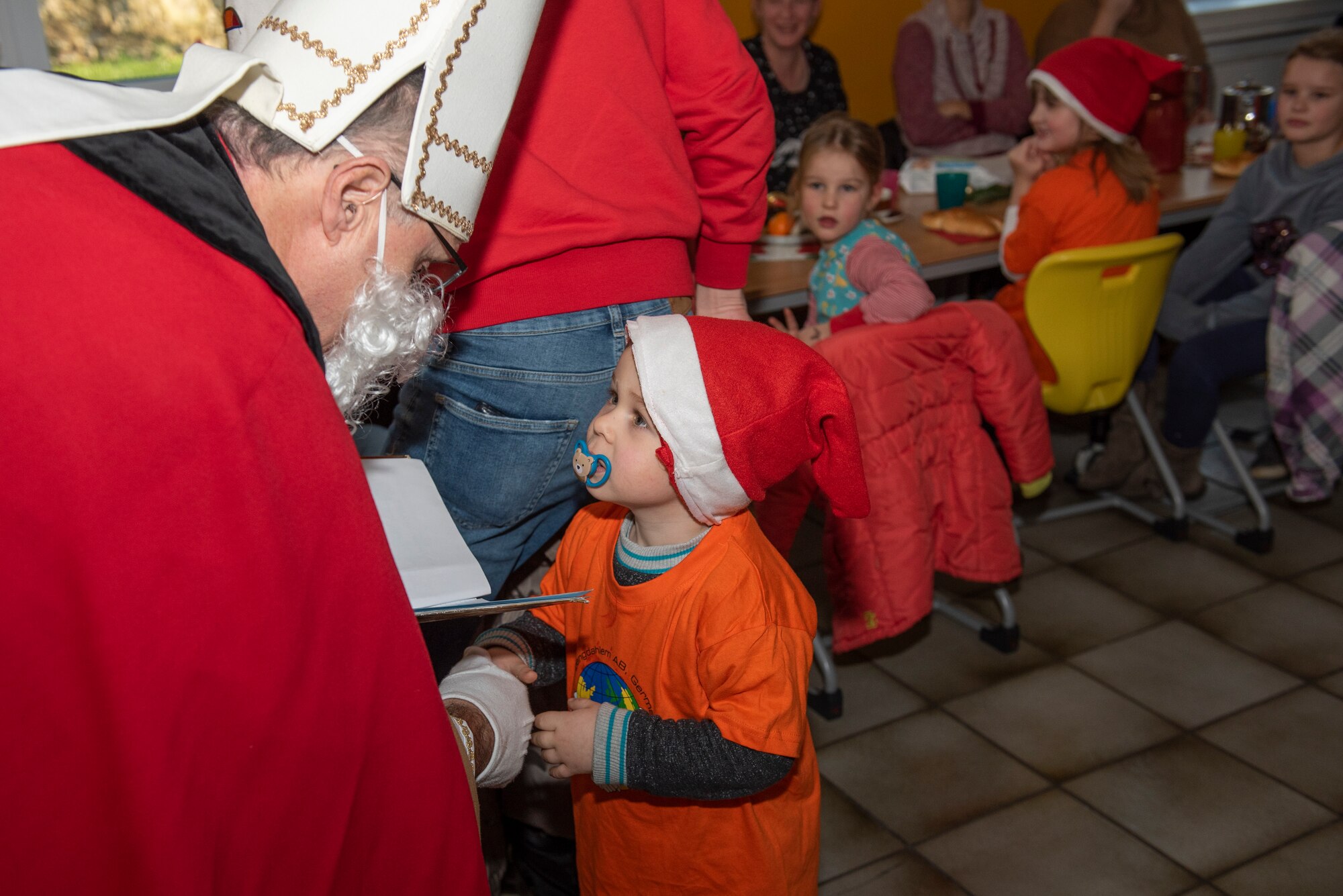 A kindergarten student greets St. Nikolaus at St. Martin's Special Children's School in Bitburg, Germany, Dec. 5, 2019. St. Nikolaus paid a visit to the students of St. Martin's School and let them know he was watching over their good deeds. (U.S. Air Force photo by Airman 1st Class Alison Stewart)