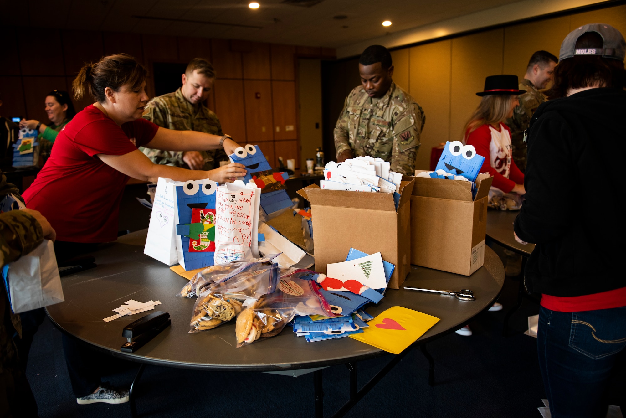 Members of the Tyndall Spouses Club and Tyndall First Sergeants assemble goodie bags during a Cookie Caper event, at Tyndall Air Force Base, Florida, Dec. 9, 2019.  Hundreds of donated cookies were collected and distributed to Airmen living in the on base dormitories, which were delivered in colorful bags handmade by students at Tyndall Elementary School. (U.S. Air Force photo by Staff Sgt. Magen M. Reeves)