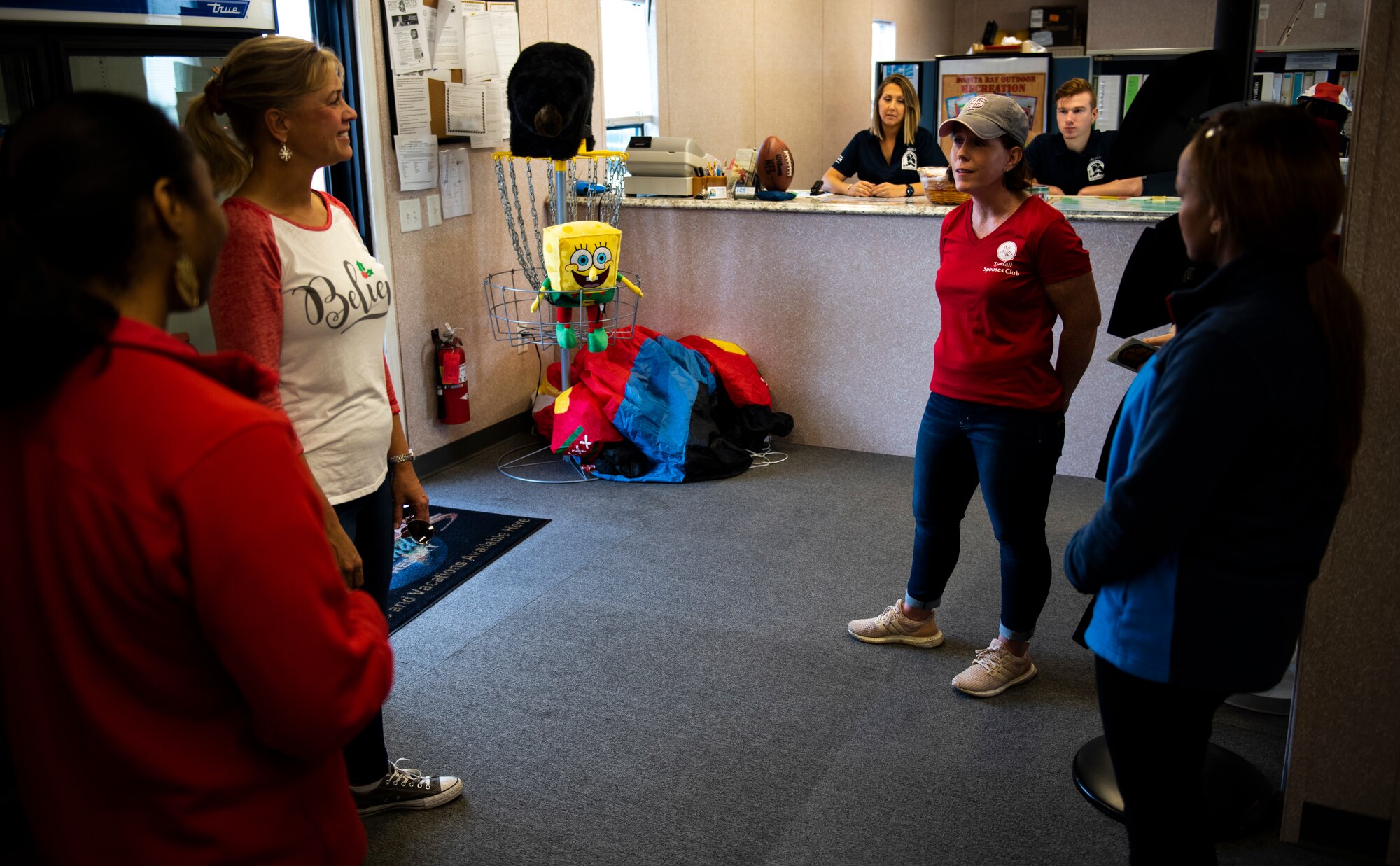 Samantha Laidlaw, left, and Amy Beaulieu, right, members of the Tyndall Spouses Club, deliver holiday cookies to the 325th Force Support Squadron outdoor recreation and information, tickets, and travel staff at Tyndall Air Force Base, Florida. Dec. 9, 2019. The Tyndall Spouses Club and the Tyndall First Sergeants organized a Cookie Caper event and received donated, homemade cookies, packaged into handmade goodie bags supplied by the Tyndall Elementary School, and delivered cookies to Airmen living in the base dormitories. Hundred of cookies were donated and extras where distributed to units and offices on base. (U.S. Air Force photo by Staff Sgt. Magen M. Reeves)